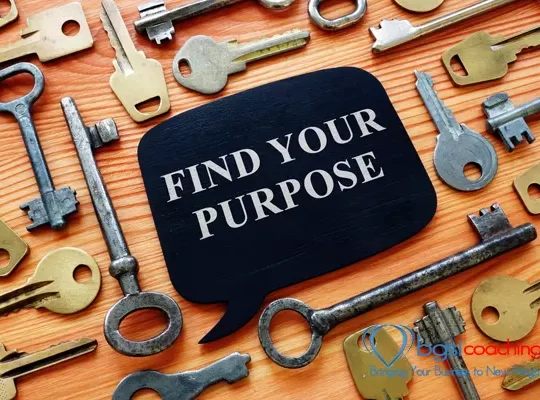 Find Your Purpose written on metallic speech ballon surrounded by keys on wooden desk